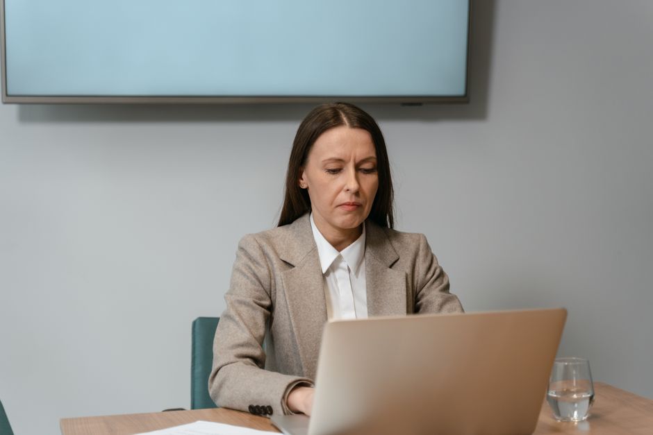 businesswoman focused on a laptop in a modern office meeting room