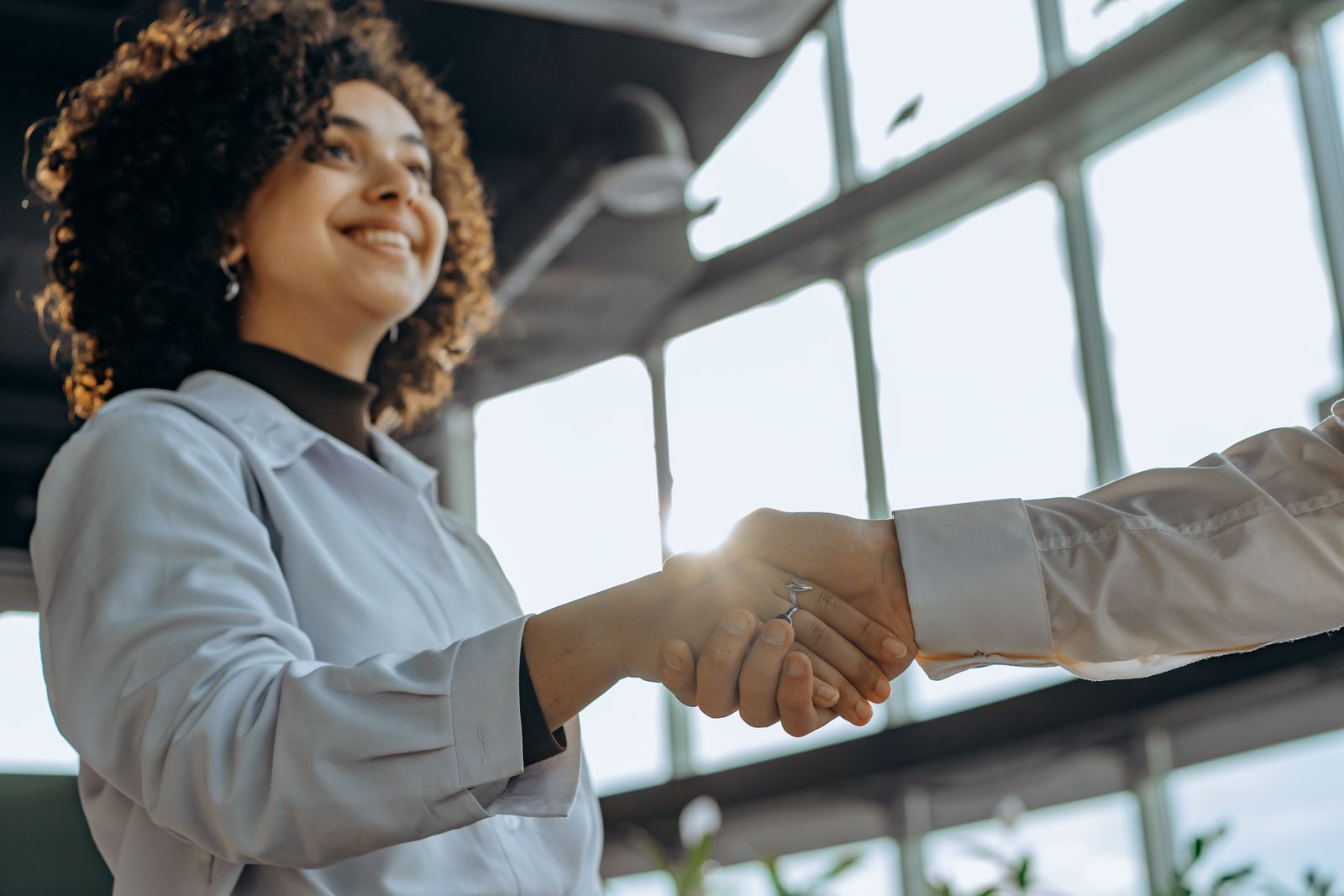 Business partners shaking hands in a bright modern office